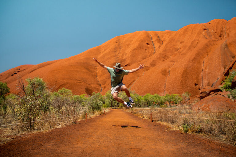 A person leaping in the air at Uluru